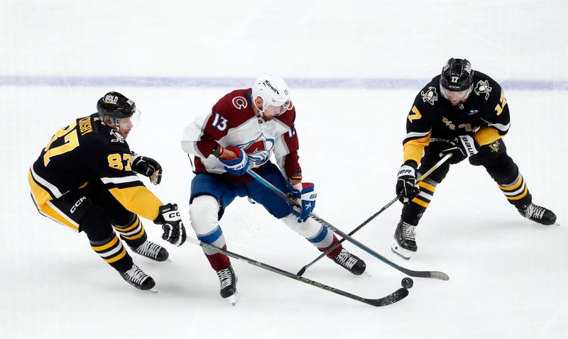 Oct 26, 2023; Pittsburgh, Pennsylvania, USA; Colorado Avalanche right wing Valeri Nichushkin (13) skates with the puck between Pittsburgh Penguins center Sidney Crosby (87) and right wing Bryan Rust (17) during the second period at PPG Paints Arena. Mandatory Credit: Charles LeClaire-USA TODAY Sports