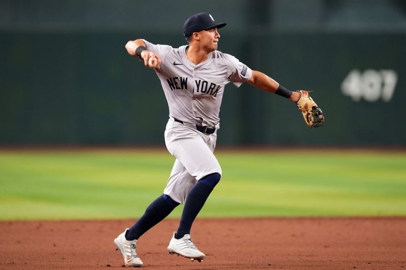 Apr 2, 2024; Phoenix, Arizona, USA; New York Yankees shortstop Anthony Volpe (11) throws to first base against the Arizona Diamondbacks during the fifth inning at Chase Field. Mandatory Credit: Joe Camporeale-USA TODAY Sports