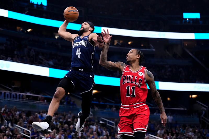 ORLANDO, FLORIDA - APRIL 07: Jalen Suggs #4 of the Orlando Magic goes up for a shot against DeMar DeRozan #11 of the Chicago Bulls during the first quarter at Kia Center on April 07, 2024 in Orlando, Florida. NOTE TO USER: User expressly acknowledges and agrees that, by downloading and or using this photograph, User is consenting to the terms and conditions of the Getty Images License Agreement. (Photo by Rich Storry/Getty Images)