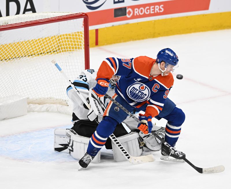 Dec 31, 2024; Edmonton, Alberta, CAN; Edmonton Oilers centre Connor McDavid (97) gets in front of Utah Hockey Club goalie Jaxson Stauber (33) during the second period at Rogers Place. Mandatory Credit: Walter Tychnowicz-Imagn Images