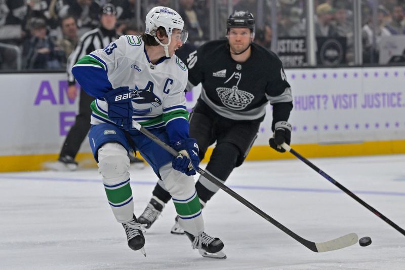 Nov 29, 2025; Los Angeles, California, USA; Vancouver Canucks defenseman Quinn Hughes (43) is pressured by Los Angeles Kings right wing Joel Armia (40) during the second period at Crypto.com Arena. Mandatory Credit: Jayne Kamin-Oncea-Imagn Images