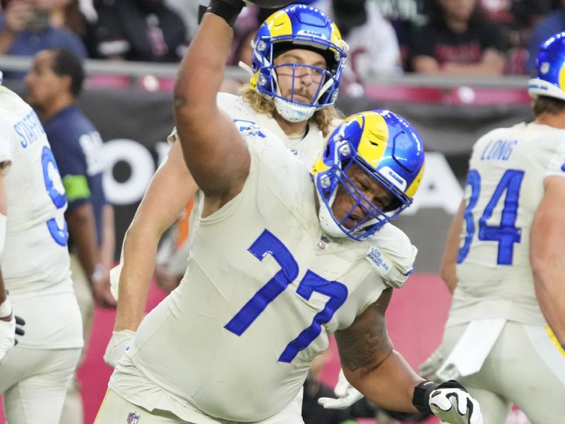 Los Angeles Rams offensive tackle Alaric Jackson (77) spikes the ball against the Arizona Cardinals during the first half of an NFL football game, Sunday, Nov. 26, 2023, in Glendale, Ariz. (AP Photo/Rick Scuteri)