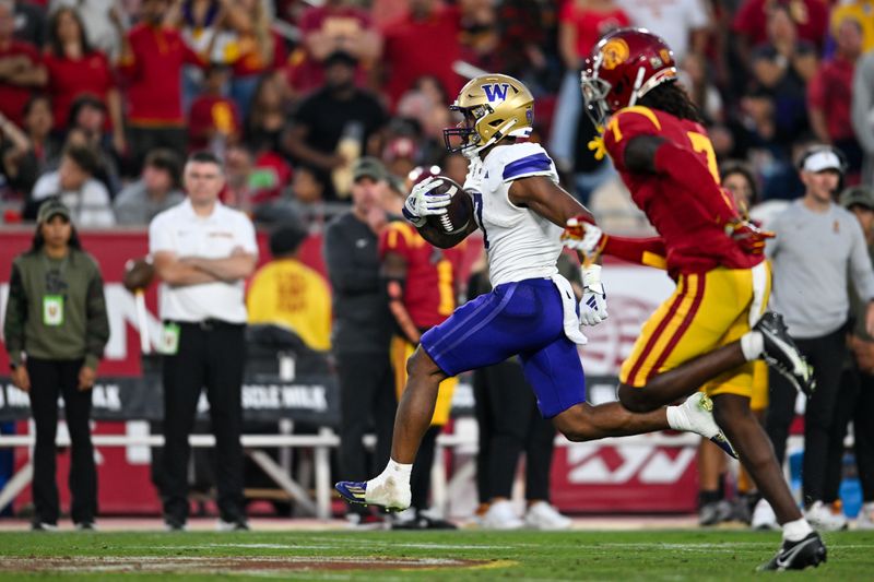 Nov 4, 2023; Los Angeles, California, USA; Washington Huskies cornerback Dominique Hampton (7) carries the ball against USC Trojans safety Calen Bullock (7) during the second quarter at United Airlines Field at Los Angeles Memorial Coliseum. Mandatory Credit: Jonathan Hui-USA TODAY Sports