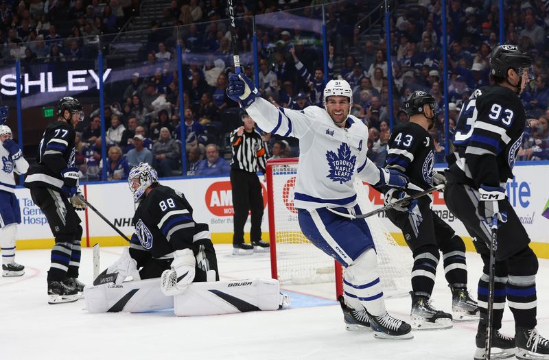 Nov 30, 2024; Tampa, Florida, USA; Toronto Maple Leafs center John Tavares (91) celebrates after defenseman Chris Tanev (8) (not pictured) scored a goal on Tampa Bay Lightning goaltender Andrei Vasilevskiy (88) during the second period at Amalie Arena. Mandatory Credit: Kim Klement Neitzel-Imagn Images