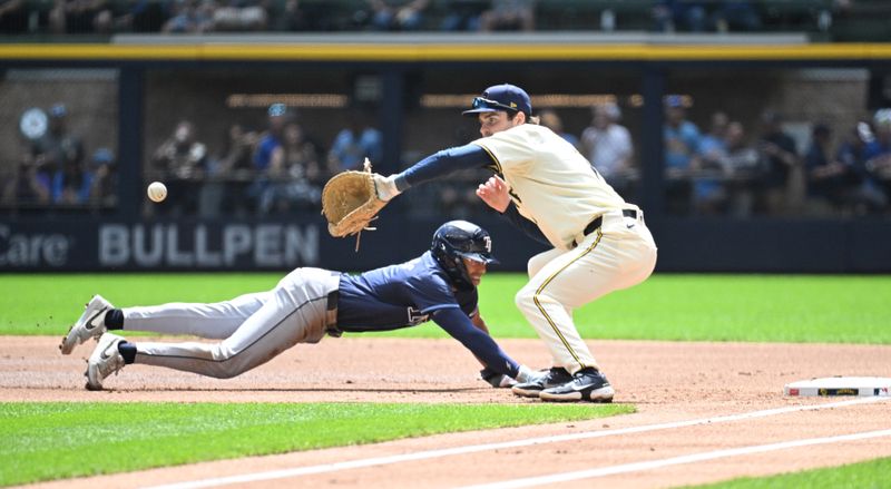 May 1, 2024; Milwaukee, Wisconsin, USA; Tampa Bay Rays outfielder Richie Palacios (1) dives back to first base ahead of the throw to Milwaukee Brewers first base Tyler Black (7) in the first inning at American Family Field. Mandatory Credit: Michael McLoone-USA TODAY Sports