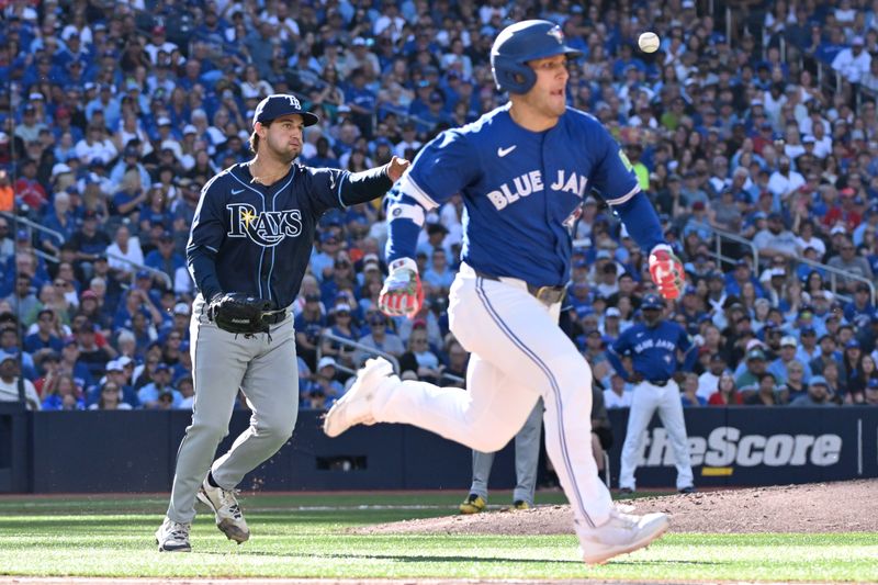 Sep 28, 2025; Toronto, Ontario, CAN;  Tampa Bay Rays pitcher Ian Seymour (61) throws to first base to force out Toronto Blue Jays center fielder Daulton Varsho (5) in the third inning at Rogers Centre. Mandatory Credit: Dan Hamilton-Imagn Images