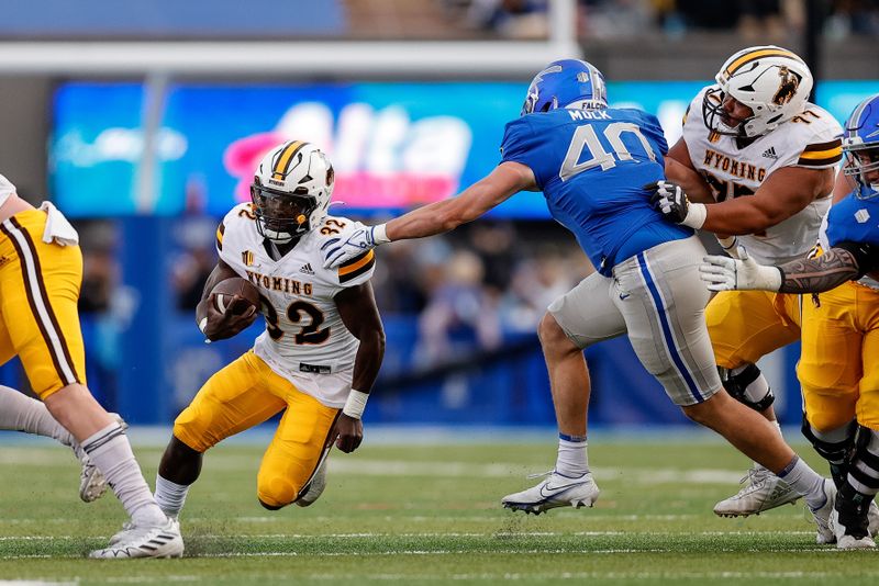 Oct 14, 2023; Colorado Springs, Colorado, USA; Wyoming Cowboys running back Jamari Ferrell (32) runs the ball against Air Force Falcons linebacker Alec Mock (40) as center Nofoafia Tulafono (77) defends in the second quarter at Falcon Stadium. Mandatory Credit: Isaiah J. Downing-USA TODAY Sports