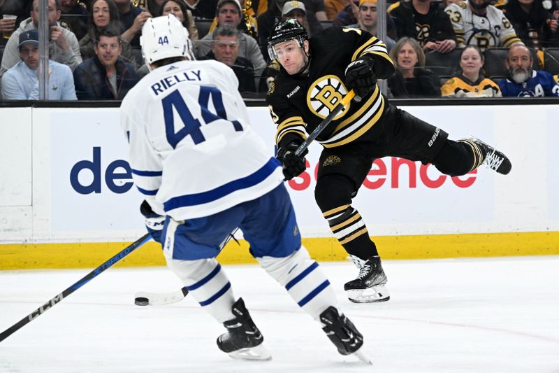 Apr 22, 2024; Boston, Massachusetts, USA; Boston Bruins center Charlie Coyle (13) takes a shot against Toronto Maple Leafs defenseman Morgan Rielly (44) during the third period in game two of the first round of the 2024 Stanley Cup Playoffs at TD Garden. Mandatory Credit: Brian Fluharty-USA TODAY Sports