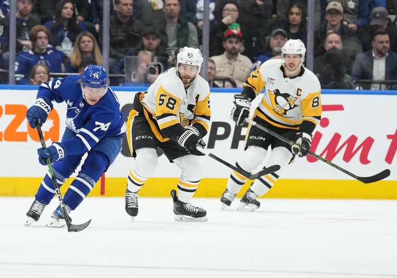 Apr 8, 2024; Toronto, Ontario, CAN; Toronto Maple Leafs center Bobby McMann (74) skates with the puck as Pittsburgh Penguins defenseman Kris Letang (58) tries to defend during the second period at Scotiabank Arena. Mandatory Credit: Nick Turchiaro-USA TODAY Sports