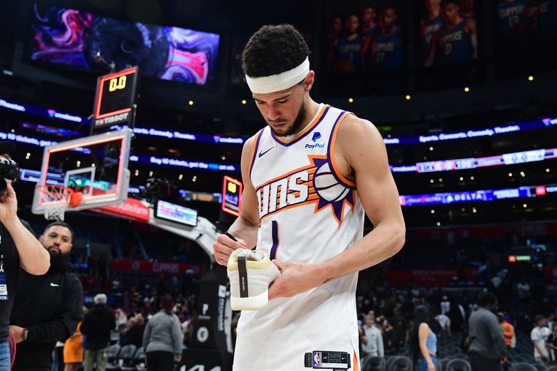 LOS ANGELES, CA - APRIL 10: Devin Booker #1 of the Phoenix Suns signs sneakers after the game against the LA Clippers on April 10, 2024 at Crypto.Com Arena in Los Angeles, California. NOTE TO USER: User expressly acknowledges and agrees that, by downloading and/or using this Photograph, user is consenting to the terms and conditions of the Getty Images License Agreement. Mandatory Copyright Notice: Copyright 2024 NBAE (Photo by Adam Pantozzi/NBAE via Getty Images)