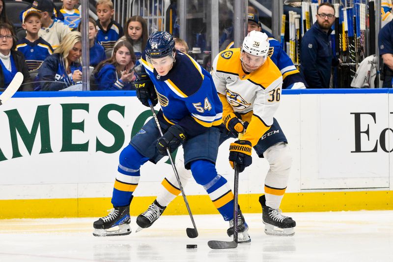 Mar 23, 2025; St. Louis, Missouri, USA;  St. Louis Blues center Dalibor Dvorsky (54) controls the puck as Nashville Predators left wing Cole Smith (36) defends during the second period at Enterprise Center. Mandatory Credit: Jeff Curry-Imagn Images