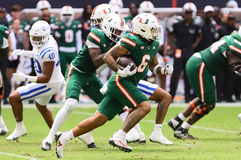 Nov 2, 2024; Miami Gardens, Florida, USA; Miami Hurricanes running back Damien Martinez (6) runs with the football against the Duke Blue Devils during the second quarter at Hard Rock Stadium. Mandatory Credit: Sam Navarro-Imagn Images