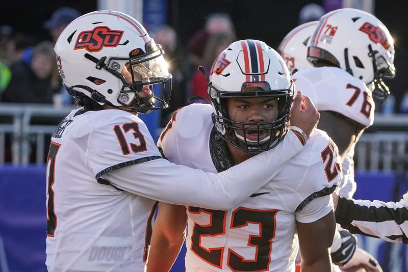 Nov 5, 2022; Lawrence, Kansas, USA; Oklahoma State Cowboys quarterback Garret Rangel (13) celebrates with running back Jaden Nixon (23) after Nixon   s touchdown against the Kansas Jayhawks during the second half of the game at David Booth Kansas Memorial Stadium. Mandatory Credit: Denny Medley-USA TODAY Sports