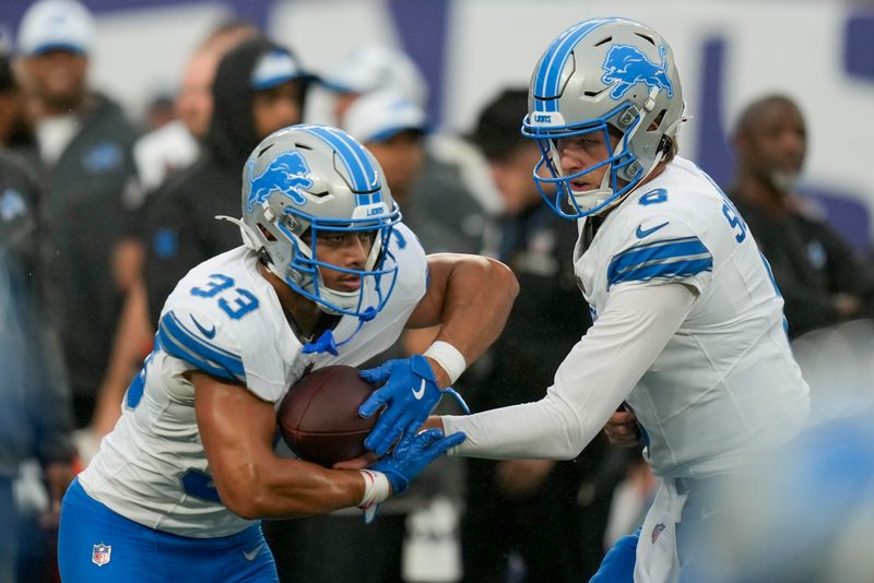 Detroit Lions quarterback Nate Sudfeld (8) hands off the ball to Detroit Lions running back Sione Vaki (33) during team warmups before an NFL football game against the New York Giants, Thursday, Aug. 8, 2024, in East Rutherford, N.J. (AP Photo/Seth Wenig)