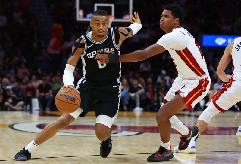 MIAMI, FLORIDA - OCTOBER 15: Keldon Johnson #0 of the San Antonio Spurs drives against Dru Smith #12 of the Miami Heat during the third quarter of a preseason game at Kaseya Center on October 15, 2024 in Miami, Florida. NOTE TO USER: User expressly acknowledges and agrees that, by downloading and or using this photograph, User is consenting to the terms and conditions of the Getty Images License Agreement. (Photo by Megan Briggs/Getty Images)