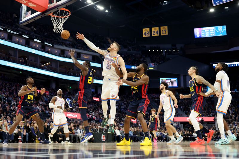 SAN FRANCISCO, CALIFORNIA - NOVEMBER 27: Isaiah Hartenstein #55 of the Oklahoma City Thunder battle for the ball against Draymond Green #23 and Andrew Wiggins #22 of the Golden State Warriors during the first half at Chase Center on November 27, 2024 in San Francisco, California. NOTE TO USER: User expressly acknowledges and agrees that, by downloading and or using this photograph, User is consenting to the terms and conditions of the Getty Images License Agreement (Photo by Ezra Shaw/Getty Images)