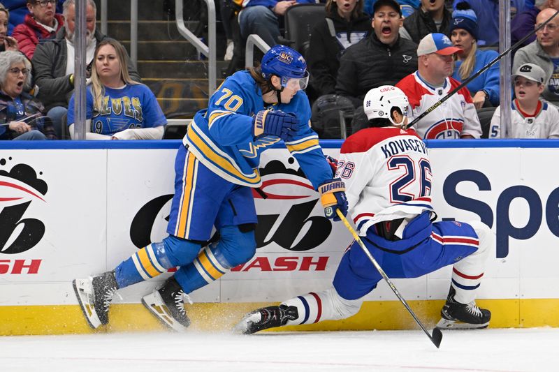 Nov 4, 2023; St. Louis, Missouri, USA; St. Louis Blues Center Oskar Sundqvist (70) checks Montreal Canadiens defenseman Johnathan Kovacevic (26) during the second period at Enterprise Center. Mandatory Credit: Jeff Le-USA TODAY Sports