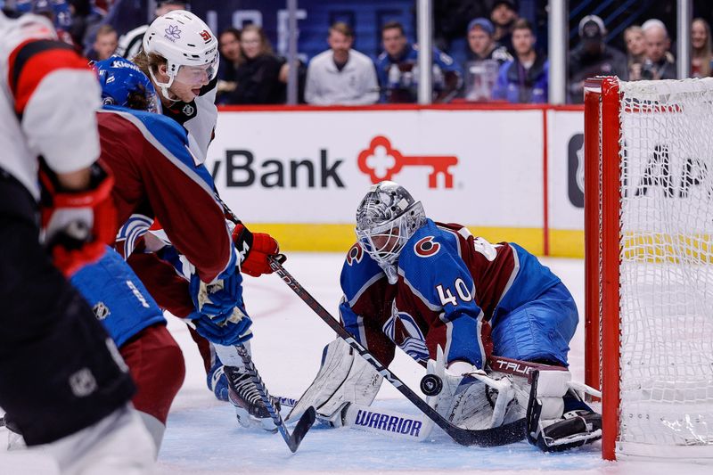 Nov 7, 2023; Denver, Colorado, USA; Colorado Avalanche goaltender Alexandar Georgiev (40) makes a save against New Jersey Devils center Dawson Mercer (91) in the first period at Ball Arena. Mandatory Credit: Isaiah J. Downing-USA TODAY Sports