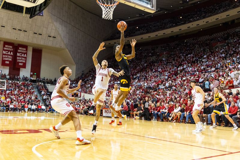 Feb 28, 2023; Bloomington, Indiana, USA; Iowa Hawkeyes guard Ahron Ulis (1) shoots the ball while Indiana Hoosiers guard Jalen Hood-Schifino (1) defends in the second half at Simon Skjodt Assembly Hall. Mandatory Credit: Trevor Ruszkowski-USA TODAY Sports