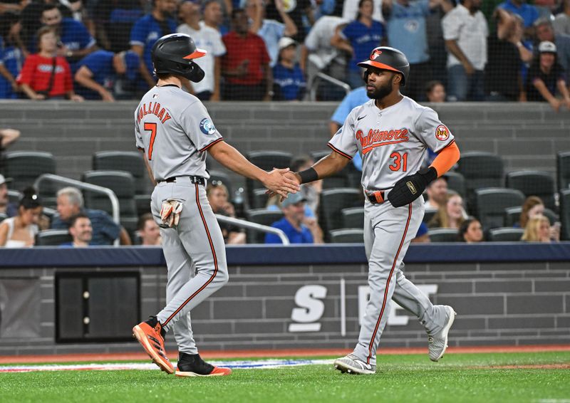 Aug 8, 2024; Toronto, Ontario, CAN; Baltimore Orioles second base Jackson Holliday (7) and center field Cedric Mullins (31) celebrate the two run single by left field Colton Cowser (17) in the ninth inning against the Toronto Blue Jays at Rogers Centre. Mandatory Credit: Gerry Angus-USA TODAY Sports