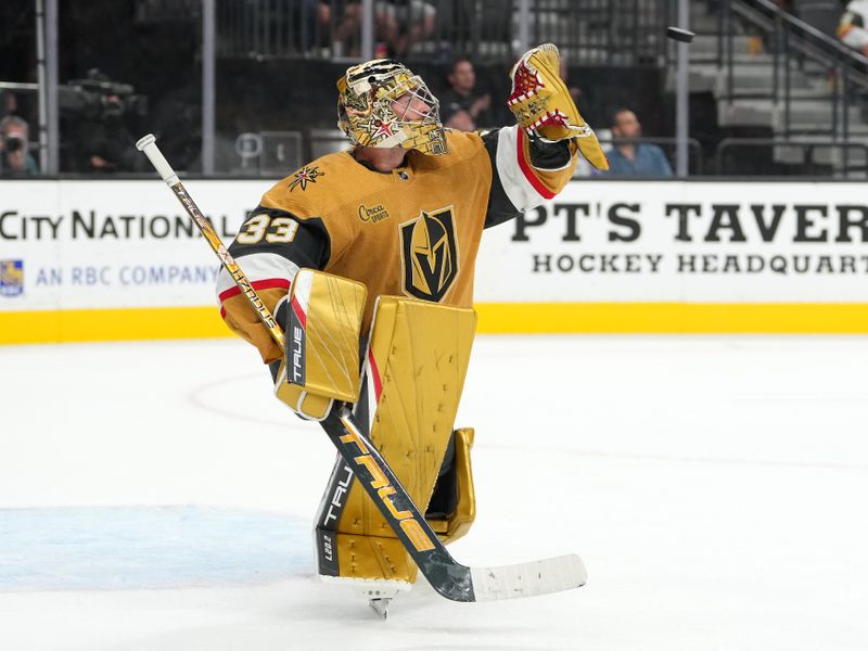 Oct 4, 2022; Las Vegas, Nevada, USA; Vegas Golden Knights goaltender Adin Hill (33) gloves the final shot by the Arizona Coyotes as the Golden Knights defeat the Coyotes 4-3 in a preseason game at T-Mobile Arena. Mandatory Credit: Stephen R. Sylvanie-USA TODAY Sports