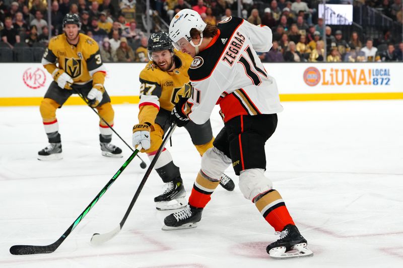 Apr 18, 2024; Las Vegas, Nevada, USA; Anaheim Ducks center Trevor Zegras (11) shoots against the stick of Vegas Golden Knights defenseman Shea Theodore (27) during the first period at T-Mobile Arena. Mandatory Credit: Stephen R. Sylvanie-USA TODAY Sports