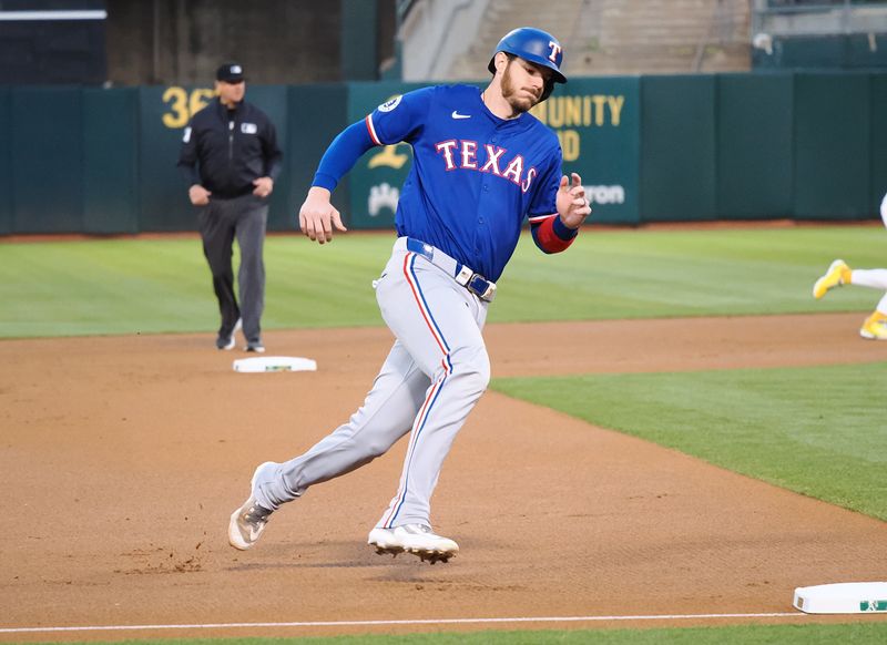 Sep 25, 2024; Oakland, California, USA; Texas Rangers catcher Jonah Heim (28) rounds third base for a run against the Oakland Athletics during the first inning at Oakland-Alameda County Coliseum. Mandatory Credit: Kelley L Cox-Imagn Images