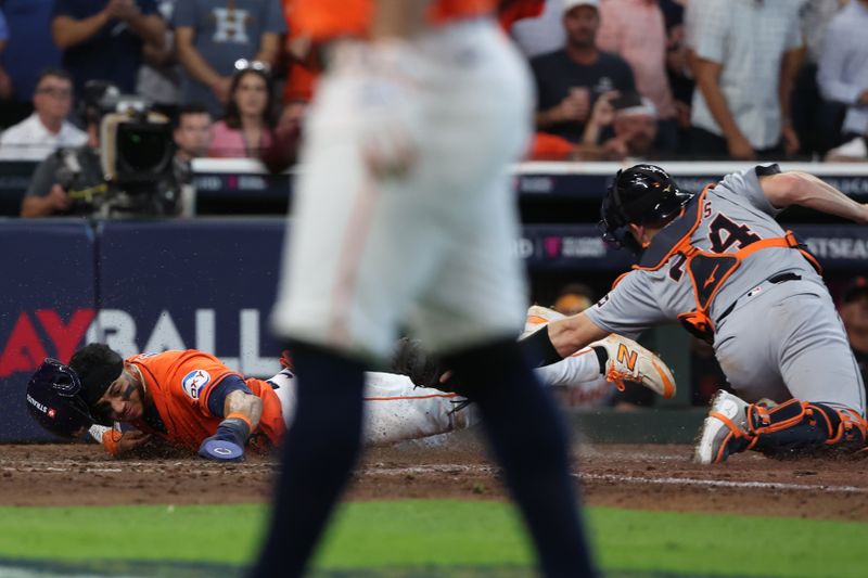 Oct 2, 2024; Houston, Texas, USA; Houston Astros shortstop Jeremy Pena (3) scores against Detroit Tigers catcher Jake Rogers (34) during the seventh inning of game two of the Wildcard round for the 2024 MLB Playoffs at Minute Maid Park. Mandatory Credit: Thomas Shea-Imagn Images