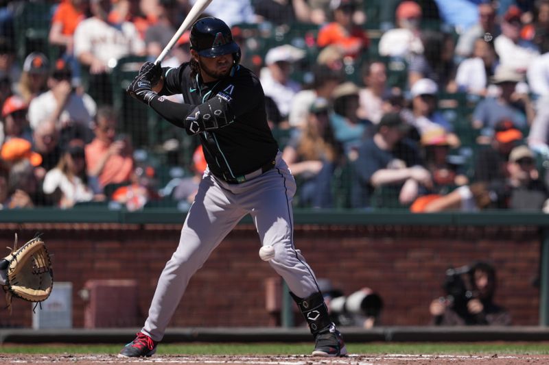 Apr 20, 2024; San Francisco, California, USA; Arizona Diamondbacks third base Eugenio Suarez (28) is hit in the knee with a pitch during the fourth inning against the San Francisco Giants at Oracle Park. Mandatory Credit: Darren Yamashita-USA TODAY Sports