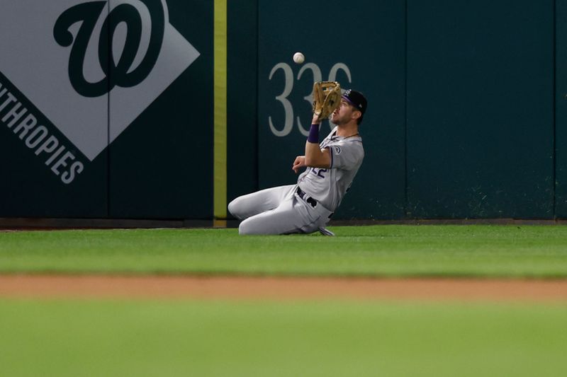 Aug 20, 2024; Washington, District of Columbia, USA; Colorado Rockies outfielder Nolan Jones (22) slides to make a catch on a fly ball hit by Washington Nationals third baseman Andrés Chaparro (not pictured) to end the eighth inning at Nationals Park. Mandatory Credit: Geoff Burke-USA TODAY Sports