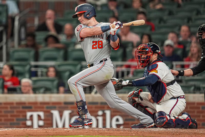 May 29, 2024; Cumberland, Georgia, USA; Washington Nationals right fielder Lane Thomas (28) singles against the Atlanta Braves during the ninth inning at Truist Park. Mandatory Credit: Dale Zanine-USA TODAY Sports