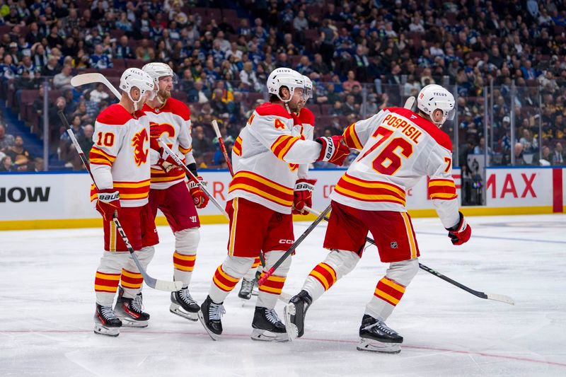 Oct 9, 2024; Vancouver, British Columbia, CAN; Calgary Flames forward Jonathan Huberdeau (10) and forward Anthony Mantha (39) and defenseman Rasmus Andersson (4) and forward Martin Pospisil (76) celebrate Pospisil’s goal against the Vancouver Canucks during the third period at Rogers Arena. Mandatory Credit: Bob Frid-Imagn Images