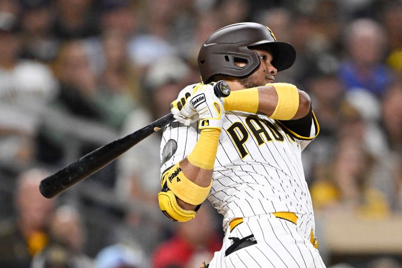 Sep 22, 2025; San Diego, California, USA; San Diego Padres first baseman Luis Arraez (4) hits an RBI single during the seventh inning against the Milwaukee Brewers at Petco Park. Mandatory Credit: Denis Poroy-Imagn Images