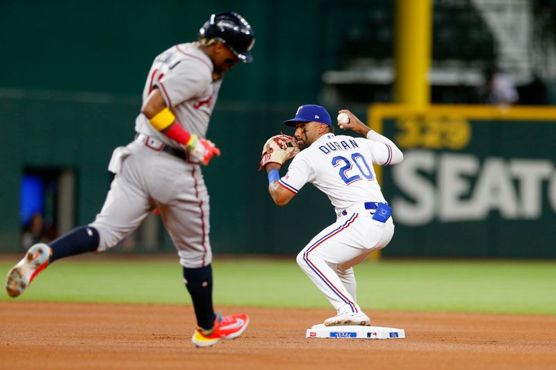 May 15, 2023; Arlington, Texas, USA; Texas Rangers shortstop Ezequiel Duran (20) turns a double play during the first inning against the Atlanta Braves at Globe Life Field. Mandatory Credit: Andrew Dieb-USA TODAY Sports