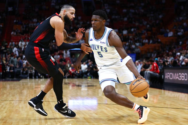 MIAMI, FLORIDA - DECEMBER 18: Anthony Edwards #5 of the Minnesota Timberwolves drives against Caleb Martin #16 of the Miami Heat during the first quarter of the game at Kaseya Center on December 18, 2023 in Miami, Florida. NOTE TO USER: User expressly acknowledges and agrees that, by downloading and or using this photograph, User is consenting to the terms and conditions of the Getty Images License Agreement. (Photo by Megan Briggs/Getty Images)