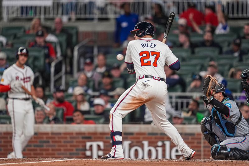 Apr 23, 2024; Cumberland, Georgia, USA; Atlanta Braves third base Austin Riley (27) is hit by a pitch against the Miami Marlins during the seventh inning at Truist Park. Mandatory Credit: Dale Zanine-USA TODAY Sports