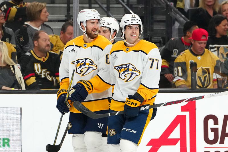 Apr 12, 2025; Las Vegas, Nevada, USA; Nashville Predators right wing Luke Evangelista (77) celebrates with Nashville Predators defenseman Jordan Oesterle (82) after scoring a goal against the Vegas Golden Knights during the first period at T-Mobile Arena. Mandatory Credit: Stephen R. Sylvanie-Imagn Images