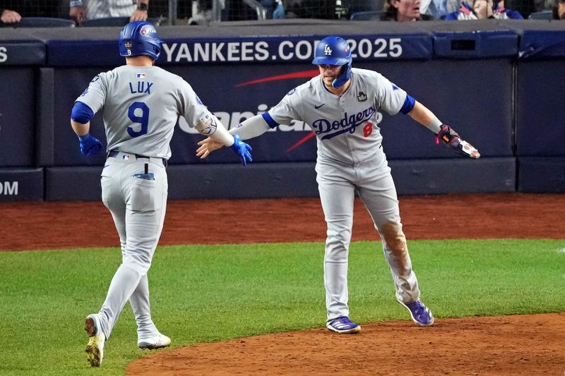 Oct 30, 2024; New York, New York, USA; Los Angeles Dodgers second baseman Gavin Lux (9) celebrates with third baseman Enrique Hernandez (8) after hitting a sacrifice fly during the eighth inning against the New York Yankees in game four of the 2024 MLB World Series at Yankee Stadium. Mandatory Credit: Robert Deutsch-Imagn Images
