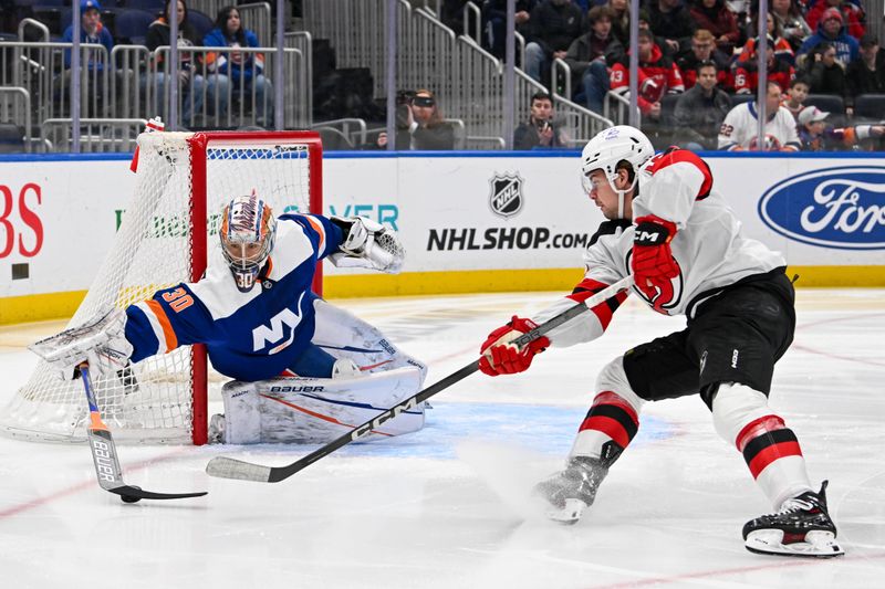 Mar 24, 2024; Elmont, New York, USA;  New York Islanders goaltender Ilya Sorokin (30) makes a save on New Jersey Devils right wing Alexander Holtz (10) during the first period at UBS Arena. Mandatory Credit: Dennis Schneidler-USA TODAY Sports