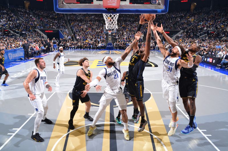 PHOENIX, AZ - NOVEMBER 12: Kevon Looney #5 of the Golden State Warriors grabs the rebound during the game against the Dallas Mavericks during the Emirates NBA Cup game on November 12, 2024 at Footprint Center in Phoenix, Arizona. NOTE TO USER: User expressly acknowledges and agrees that, by downloading and or using this photograph, user is consenting to the terms and conditions of the Getty Images License Agreement. Mandatory Copyright Notice: Copyright 2024 NBAE (Photo by Barry Gossage/NBAE via Getty Images)