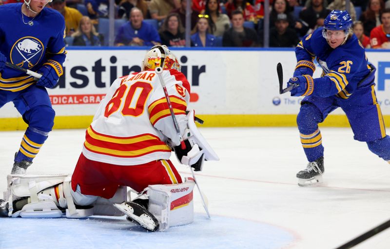 Nov 9, 2024; Buffalo, New York, USA;  Calgary Flames goaltender Dan Vladar (80) makes a blocker save on Buffalo Sabres defenseman Rasmus Dahlin (26) during the second period at KeyBank Center. Mandatory Credit: Timothy T. Ludwig-Imagn Images