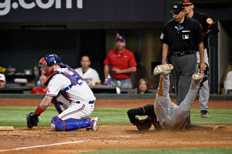 Oct 10, 2023; Arlington, Texas, USA; Baltimore Orioles second baseman Jordan Westburg (11) slides to score against Texas Rangers catcher Jonah Heim (28) in the fifth inning during game three of the ALDS for the 2023 MLB playoffs at Globe Life Field. Mandatory Credit: Jerome Miron-USA TODAY Sports