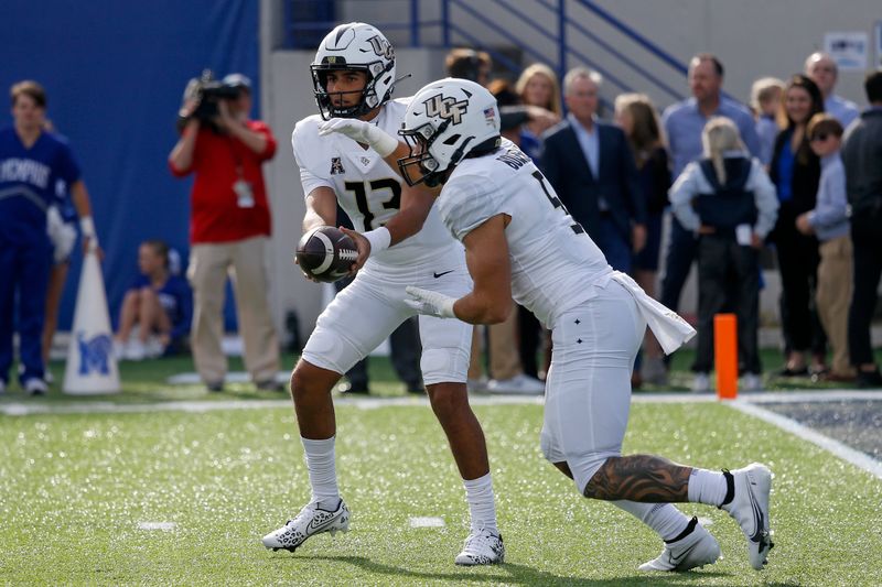 Nov 5, 2022; Memphis, Tennessee, USA; UCF Knights quarterback Mikey Keene (13) hands the ball off to running back Isaiah Bowser (5) during the first half against the Memphis Tigers at Liberty Bowl Memorial Stadium. Mandatory Credit: Petre Thomas-USA TODAY Sports