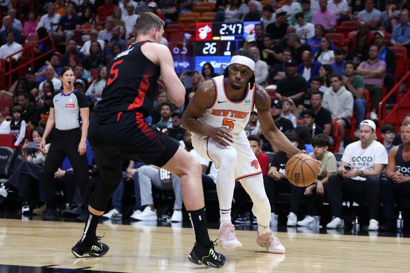 MIAMI, FLORIDA - APRIL 02: Precious Achiuwa #5 of the New York Knicks drives against Nikola Jovic #5 of the Miami Heat during the first quarter of the game at Kaseya Center on April 02, 2024 in Miami, Florida. NOTE TO USER: User expressly acknowledges and agrees that, by downloading and or using this photograph, User is consenting to the terms and conditions of the Getty Images License Agreement. (Photo by Megan Briggs/Getty Images)