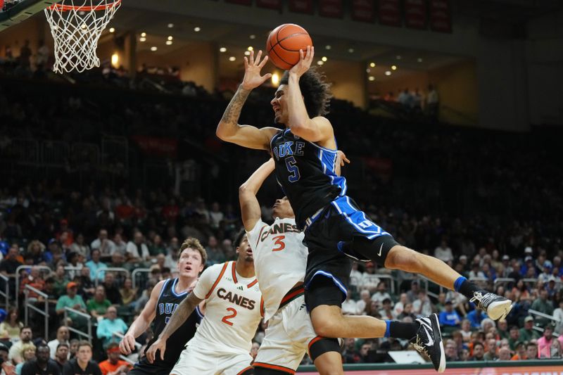 Feb 25, 2025; Coral Gables, Florida, USA;  Duke Blue Devils guard Tyrese Proctor (5) gets fouled by Miami (Fl) Hurricanes guard Jalil Bethea (3) during the first half at Watsco Center. Mandatory Credit: Jim Rassol-Imagn Images