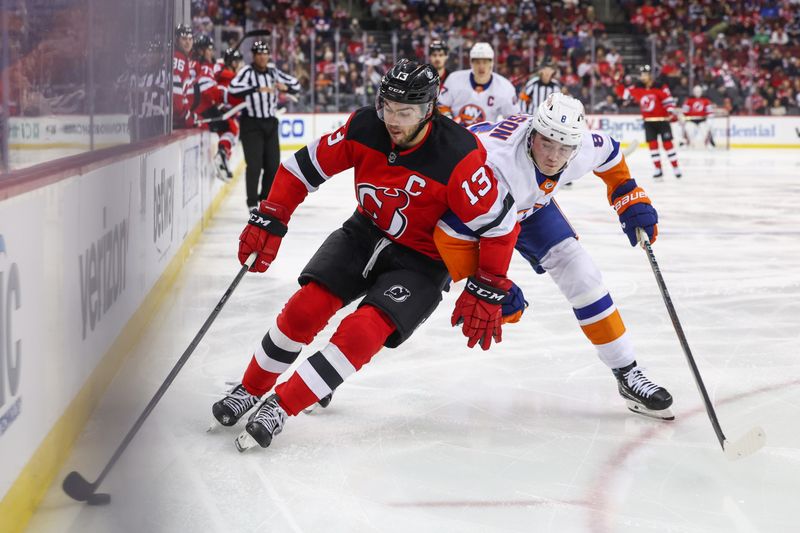 Nov 28, 2023; Newark, New Jersey, USA; New Jersey Devils center Nico Hischier (13) skates with the puck while being defended by New York Islanders defenseman Noah Dobson (8) during the second period at Prudential Center. Mandatory Credit: Ed Mulholland-USA TODAY Sports