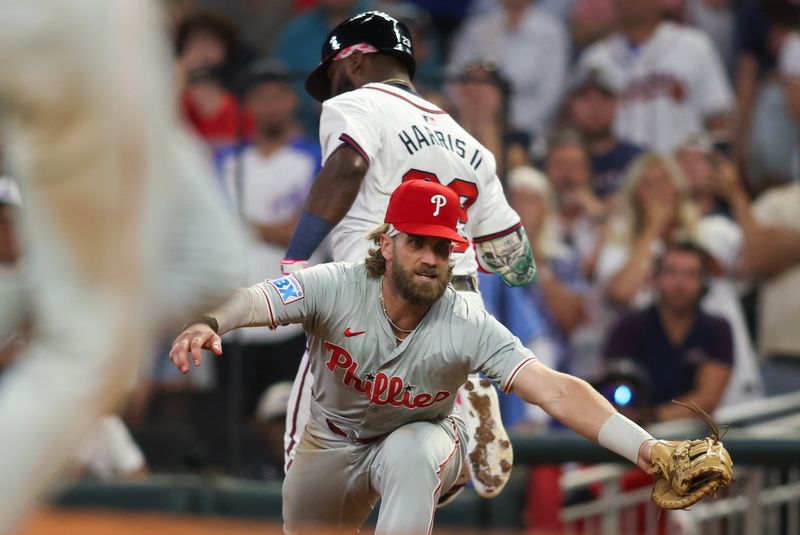 Aug 21, 2024; Atlanta, Georgia, USA; Philadelphia Phillies first baseman Bryce Harper (3) forces out Atlanta Braves center fielder Michael Harris II (23) in the ninth inning at Truist Park. Mandatory Credit: Brett Davis-USA TODAY Sports