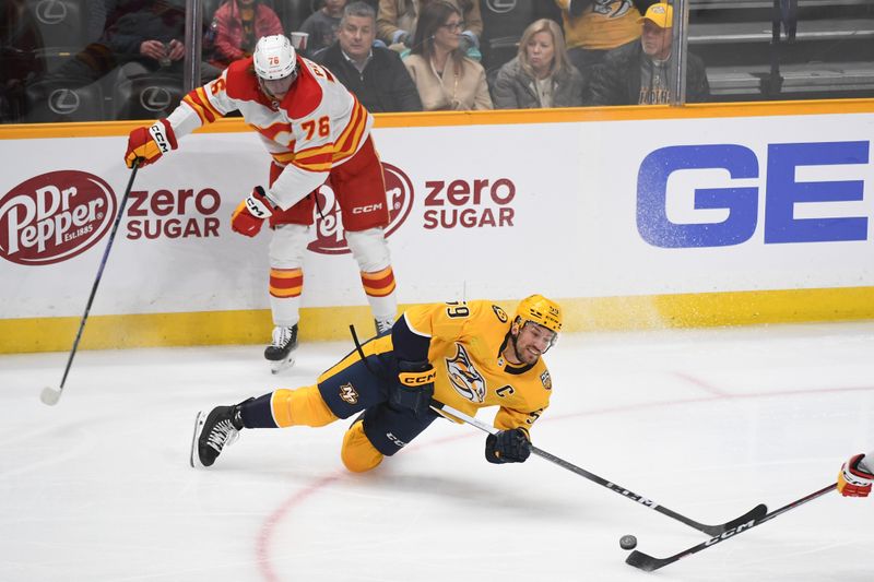 Jan 4, 2024; Nashville, Tennessee, USA; Nashville Predators defenseman Roman Josi (59) loses the puck as he falls to the ice after a hit by Calgary Flames center Martin Pospisil (76) during the first period at Bridgestone Arena. Mandatory Credit: Christopher Hanewinckel-USA TODAY Sports