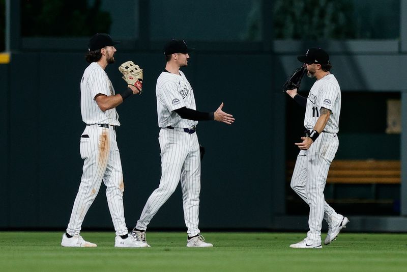 Aug 6, 2024; Denver, Colorado, USA; Colorado Rockies left fielder Sam Hilliard (16) and center fielder Brenton Doyle (9) and right fielder Jake Cave (11) celebrate after the game against the New York Mets at Coors Field. Mandatory Credit: Isaiah J. Downing-USA TODAY Sports