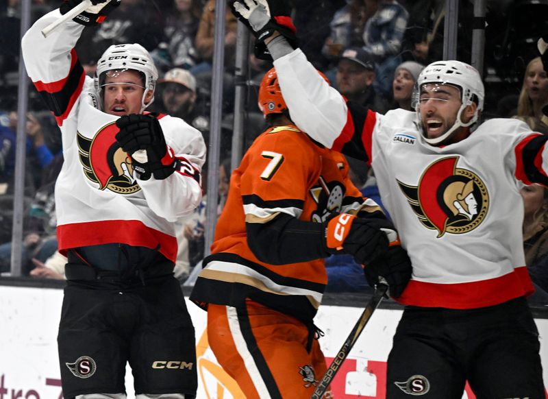 Dec 1, 2024; Anaheim, California, USA;  Ottawa Senators center Nick Cousins (left) celebrates his goal with right wing Michael Amadio (right) against Anaheim Ducks defenseman Radko Gudas (7) during the third period at Honda Center. Mandatory Credit: Alex Gallardo-Imagn Images